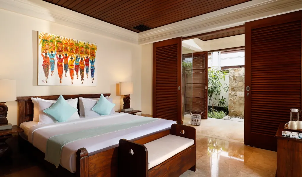 Bedroom with a double bed, colorful art, and an outdoor shower at Villa The Seven