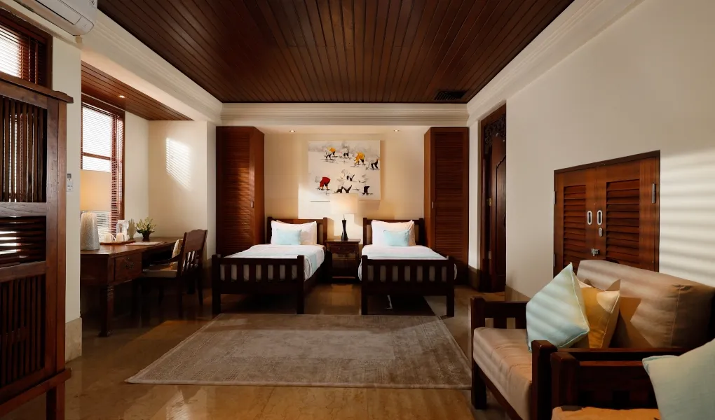 Guest room with two single beds, a desk, and wooden furniture at Villa The Seven