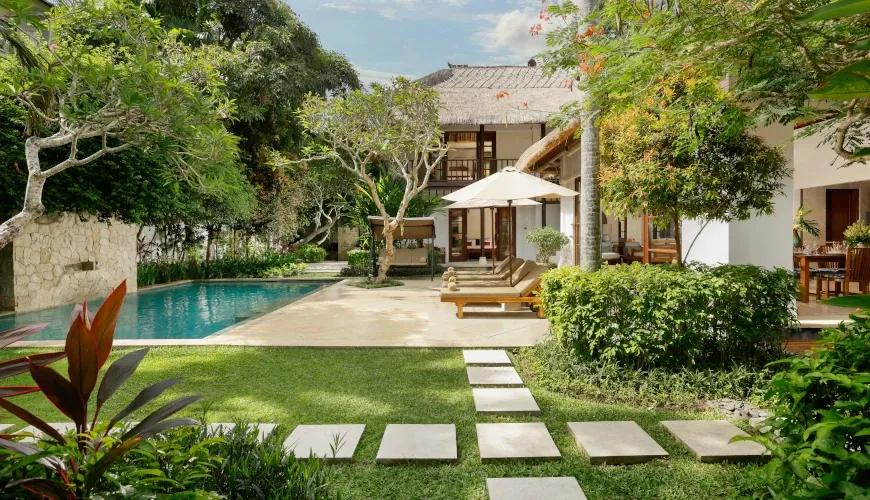 Expansive outdoor pool area with lush garden at Villa Ohm