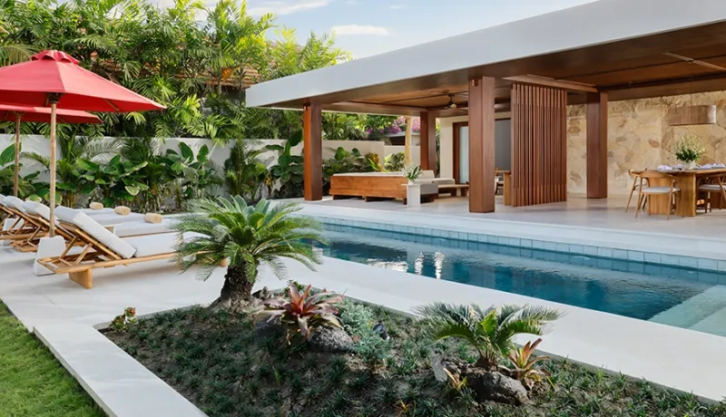 Luxurious two bedroom villa swimming pool area with sun loungers and comfortable outdoor patio dining at Amarta Beach Retreat 2BR Villa