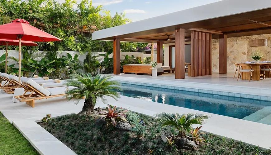 Luxurious two bedroom villa swimming pool area with sun loungers and comfortable outdoor patio dining at Amarta Beach Retreat 2BR Villa