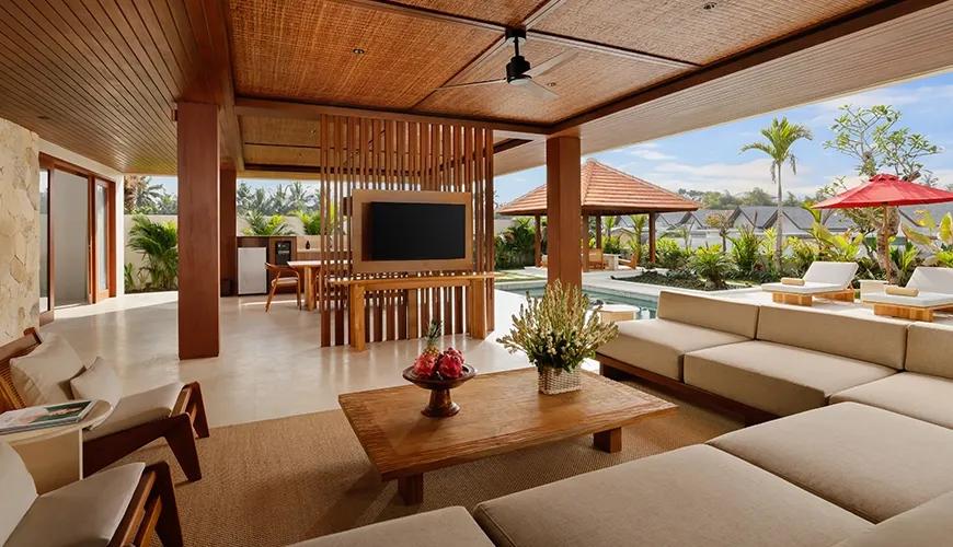 Open plan indoor outdoor living area in a two bedroom villa featuring comfortable large sofa and television at Amarta Beach Retreat 2BR Villa