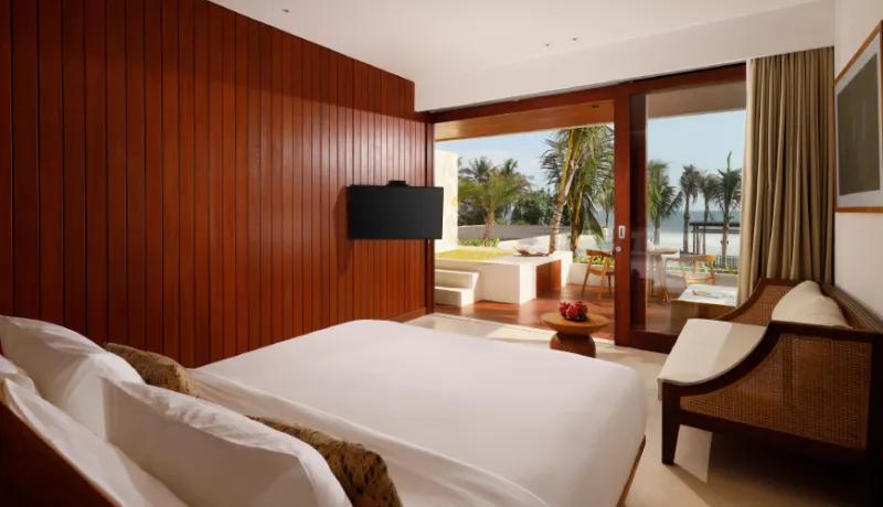 Bright naturalist suite with a plush bed and a terrace jacuzzi facing the beautiful blue ocean at Amarta Beach Retreat