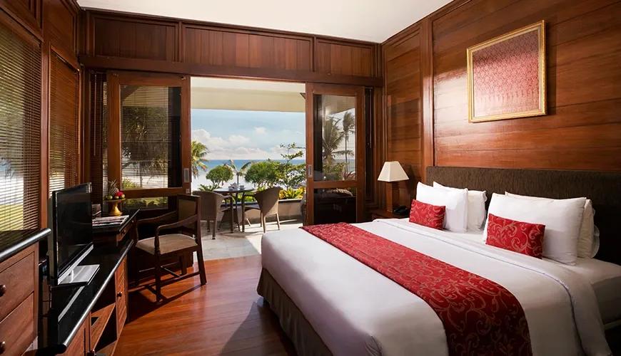Classic Balinese-style bedroom with a private balcony and ocean view at amarta beach retreat