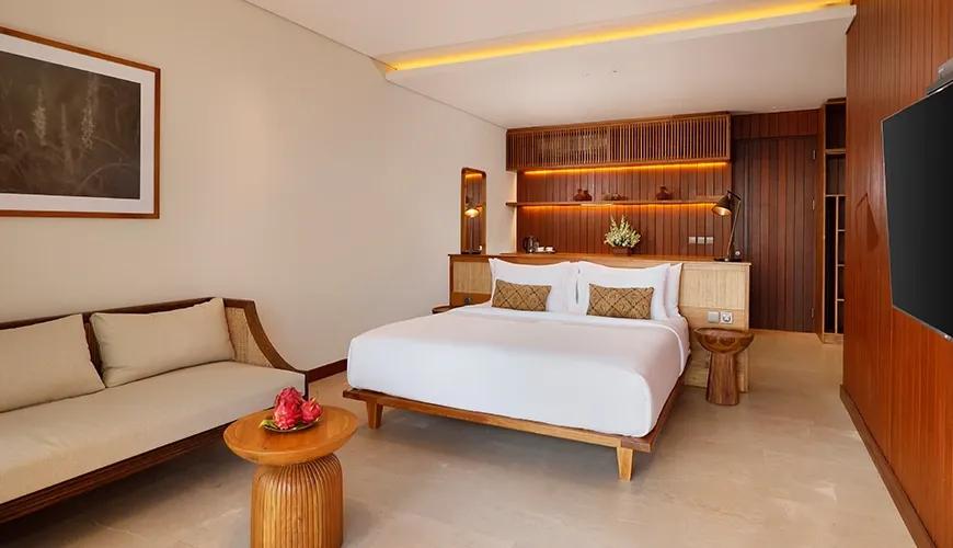 Modern hotel bedroom with wooden accents and Balinese-style furniture at amarta beach retreat