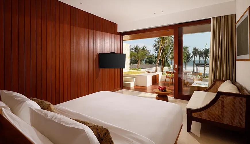 oceanfront bedroom with wooden paneling and a private jacuzzi at amarta beach retreat