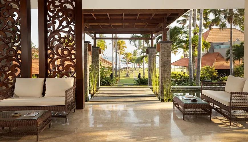 Spacious hotel lobby with open-air design, Balinese carvings, and ocean view at amarta beach retreat