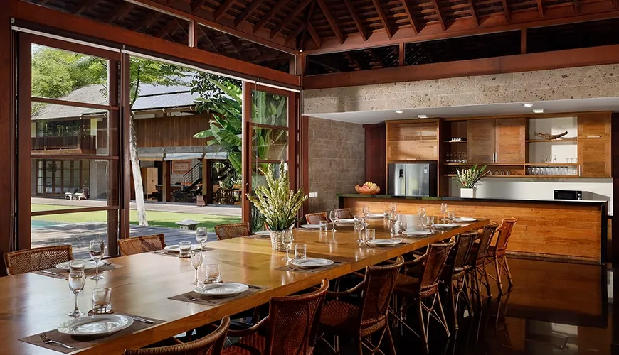 Spacious open-concept kitchen and dining with a long table at Amita Villa