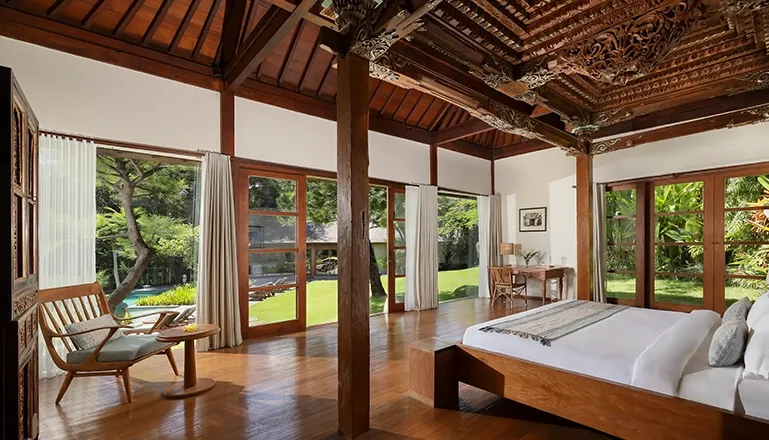 Traditional wooden Joglo interior with intricate carvings at Amita Villa