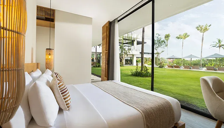 Spacious bedroom with a bed and large windows overlooking the garden at Arita Villa