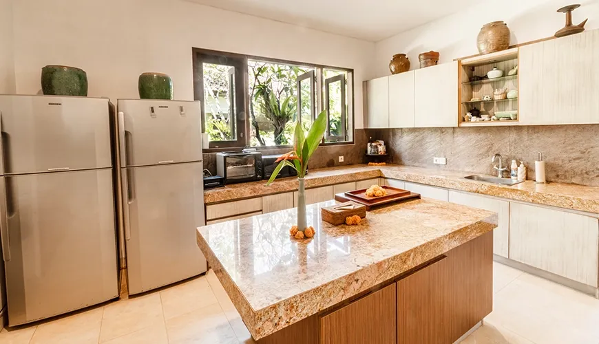 Fully equipped modern villa kitchen featuring a large granite island, stainless steel refrigerators, and ample cabinet storage at Asraya Villa