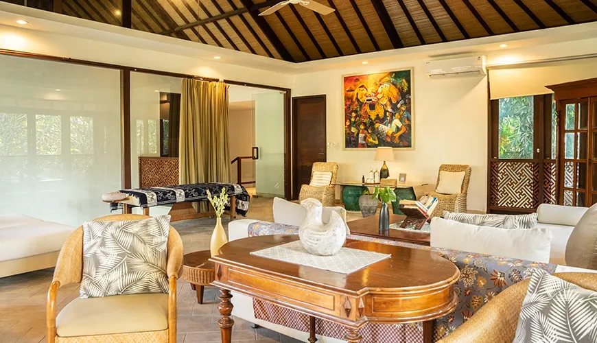 Luxurious villa interior featuring a comfortable seating arrangement, traditional furniture, and a separate space with an in-room massage bed at Asraya Villa