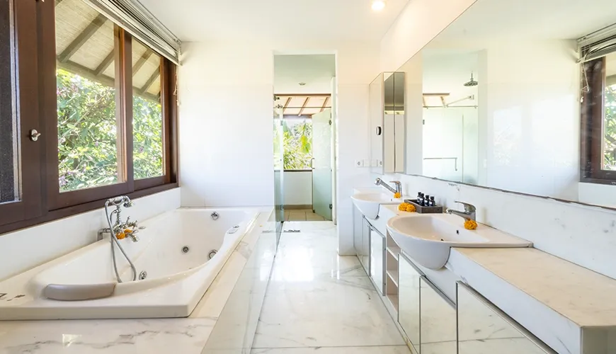 Luxurious master suite bathroom featuring white marble counters, a large jetted tub, and spacious double vanities perfect for couple at Asraya Villa