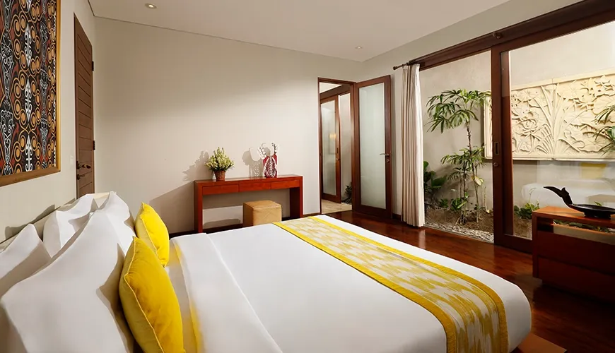 Luxurious master bedroom white bed yellow accents private outdoor garden at Bumbak Park