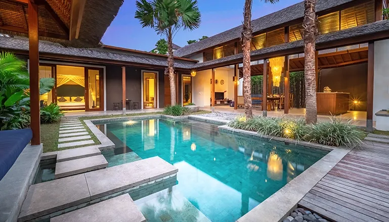 Luxurious villa private pool courtyard design lush palm trees evening lighting at Bumbak Park