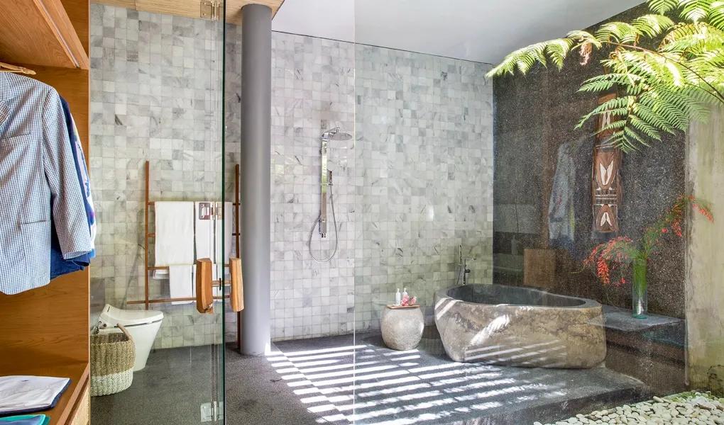 Luxurious bathroom with a natural stone tub and glass shower at casaBama