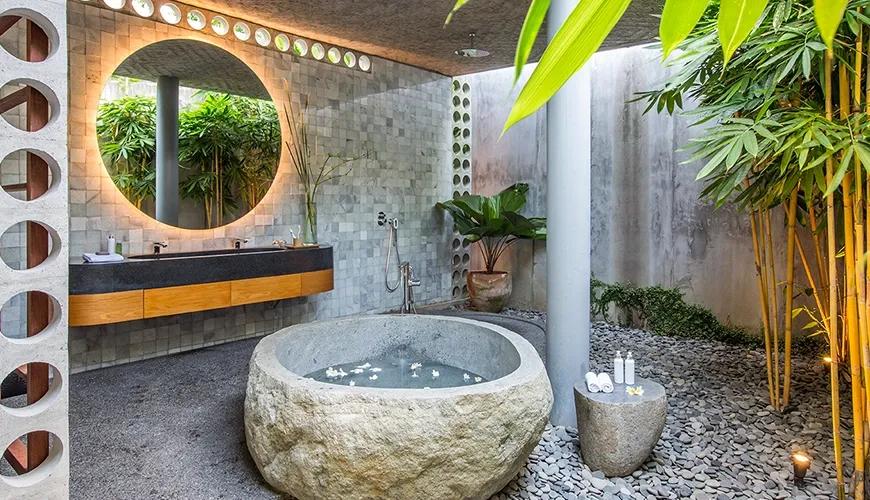 Sleek kitchen features a breakfast bar, integrated concrete staircase, and lush greenery at caSabama