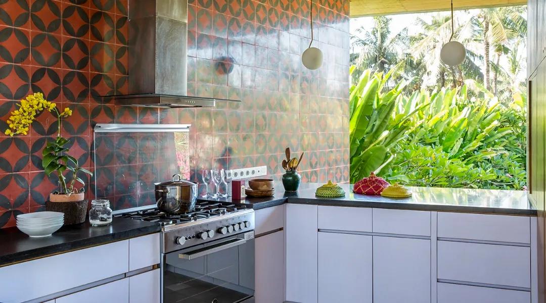 Open-air kitchen with colorful tiles and garden view at casaBama