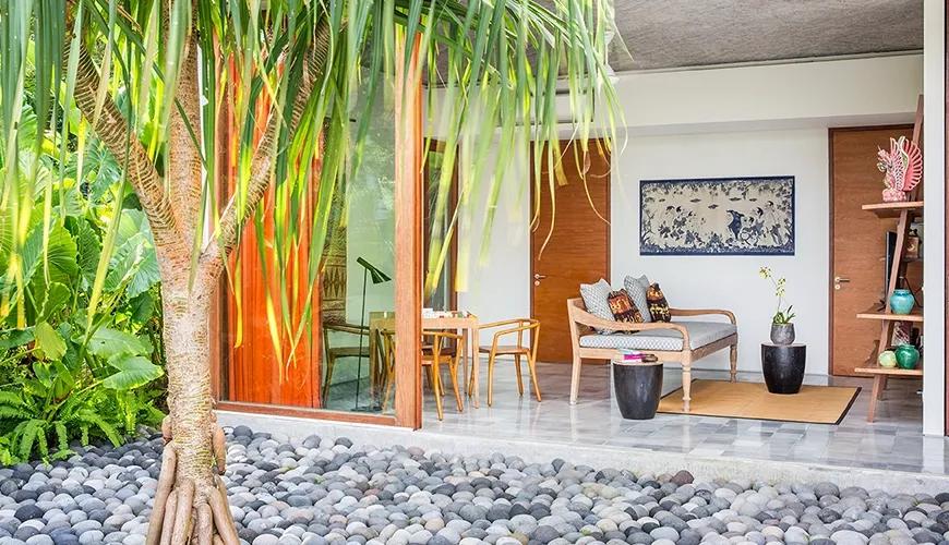 Open living space features unique pebble flooring and vibrant outdoor vista at caSabama