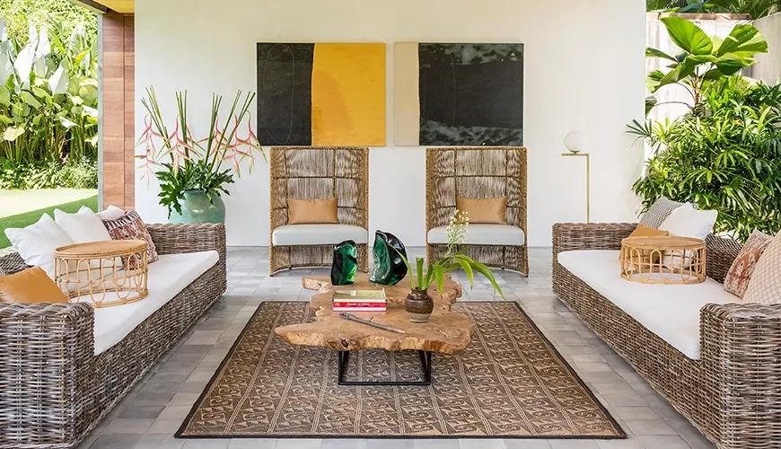 Stylish open-air living area features woven furniture and striking abstract wall art at caSabama