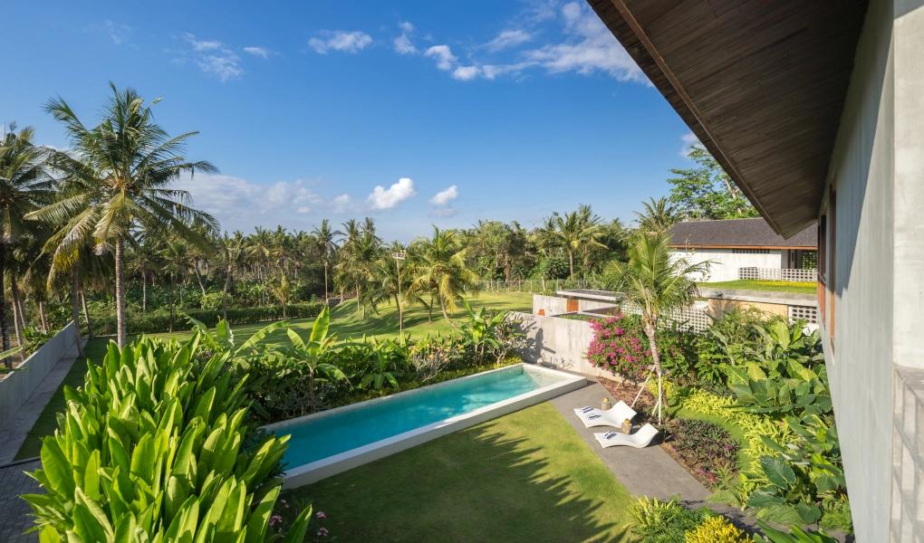 Tropical villa with lush garden, long pool, and palm trees at casaBama