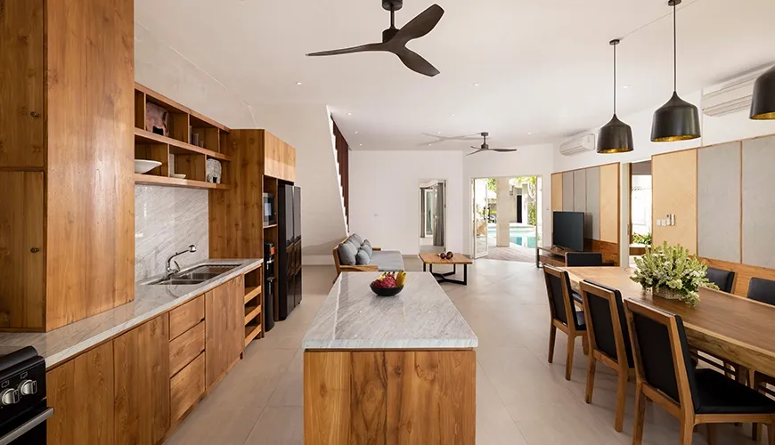 Beautifully designed open concept dining room with a stunning wooden dining table and black chairs at Christie Villa