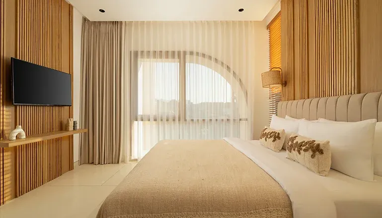 Elegant bedroom with a king-size bed and wooden accents at Fenta Villa