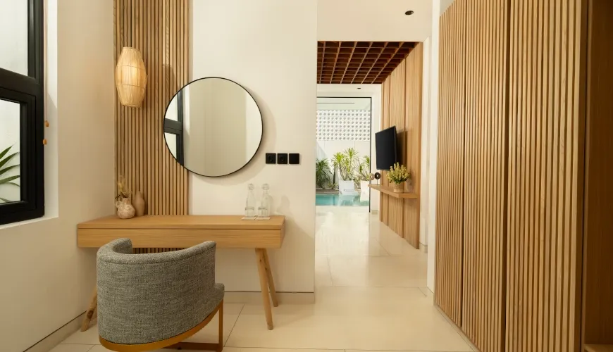 Elegant dressing area with wooden accents and a round mirror at Fenta Villa