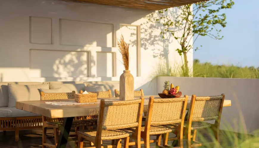 Outdoor rooftop lounge and dining area with woven chairs at Fenta Villa