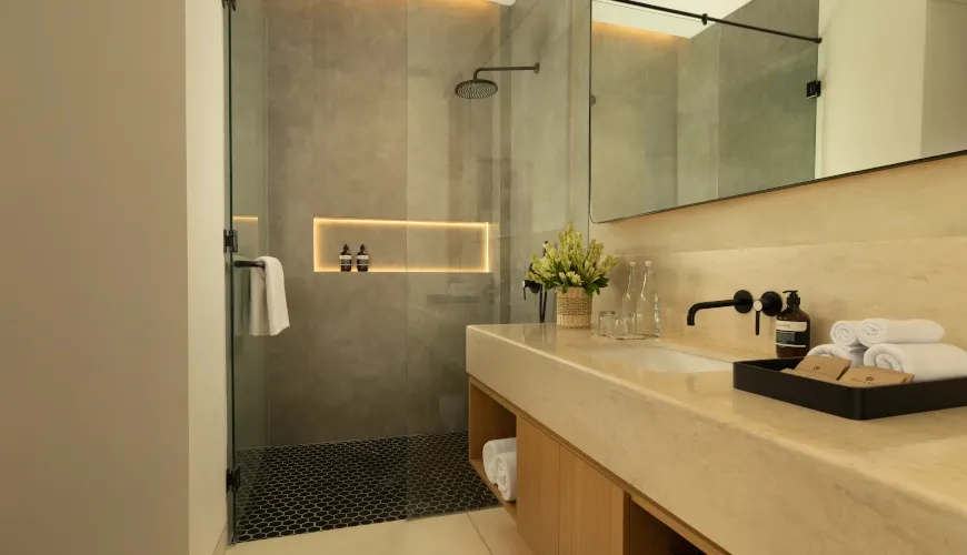 Sleek, modern bathroom with glass shower and dual vanities at Fenta Villa