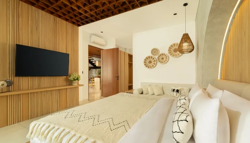 Warm Balinese master bedroom with wooden accents and natural decor at Fenta Villa