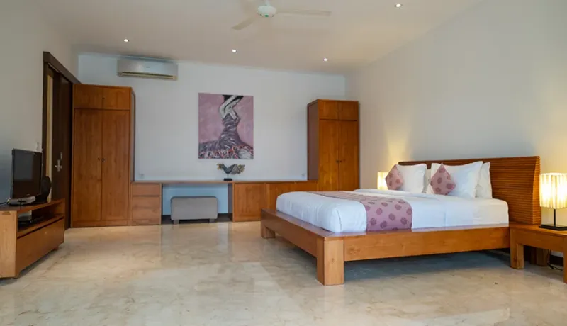 Elegant Bali villa bedroom with modern wooden furniture at Istana Putih Villa