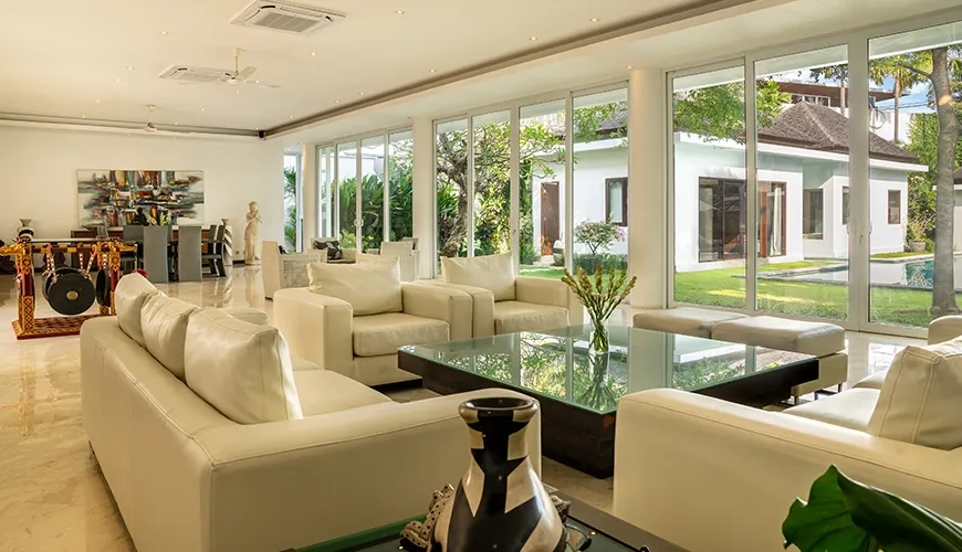 Elegant open plan living area with plush seating and floor-to-ceiling windows overlooking the villa's outdoor space at Istana Putih Villa