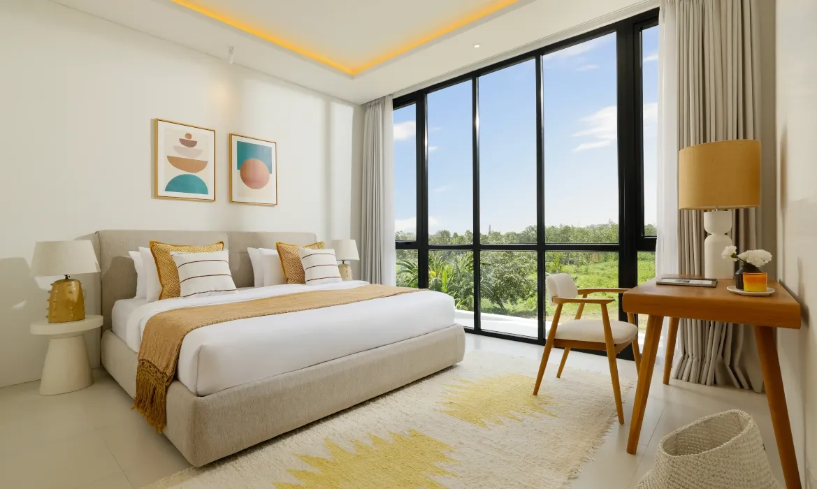 Bright bedroom featuring large window with lush outdoor scenery at Kalem Canggu