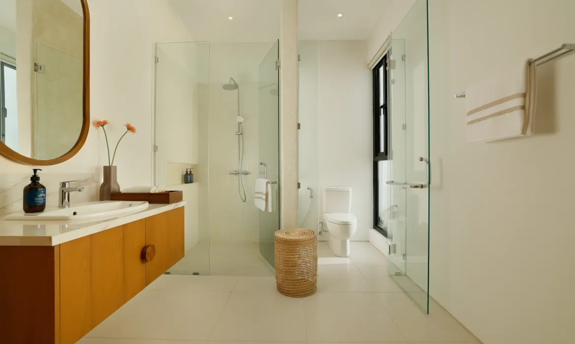 Modern minimalist bathroom with walk-in shower and natural light at Kalem Canggu