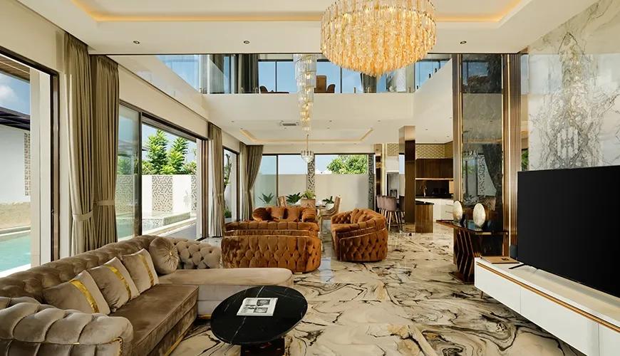 Luxurious double height living area with marble surfaces and glass doors overlooking the outdoor swimming pool at Kalem Uluwatu