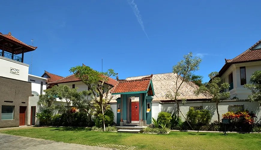 The traditional entrance of a beautiful villa surrounded by lush greenery and classic Balinese architecture at Kama Village 1BR