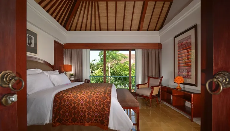 Traditional master bedroom with a wood theme and a private balcony overlooking the resort at Kama Village 2BR