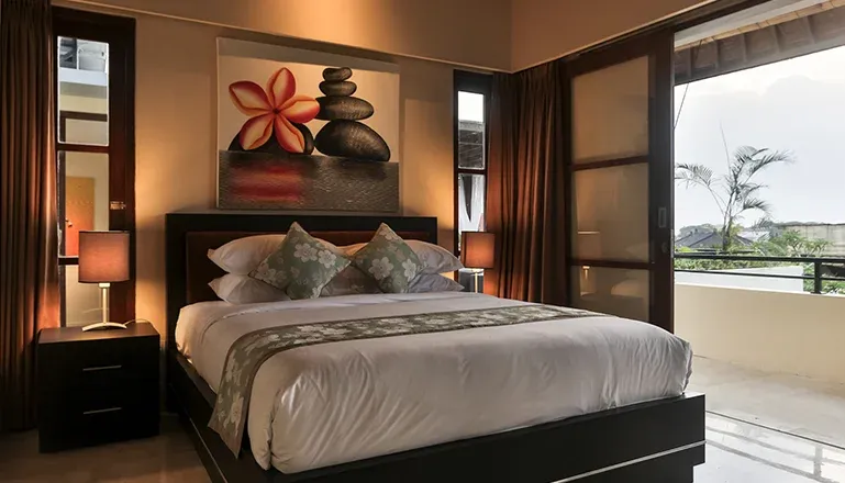 Luxurious bedroom with a comfortable bed and private balcony at Kumuda Villa