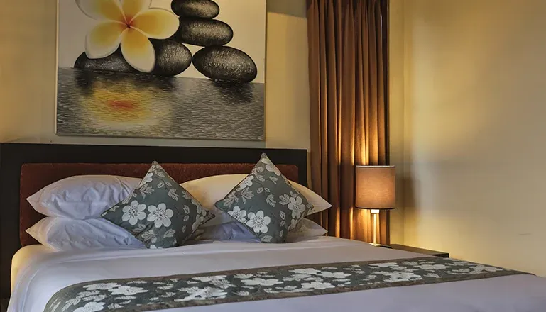 Well-lit bedroom featuring a large bed and floral accents at Kumuda Villa