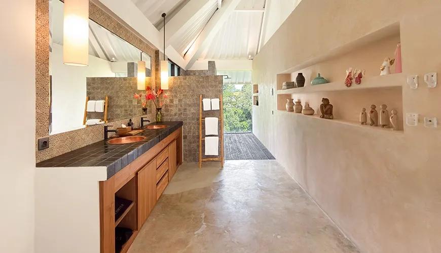 Spacious luxury Maharaja Bathroom with vaulted ceilings, double copper sinks, and open shelving for decor items at Le Sunset
