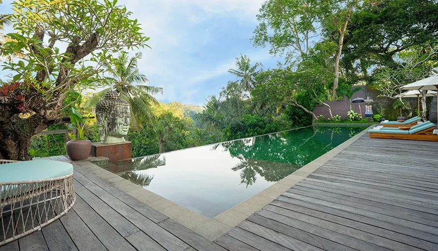 Beautiful infinity pool on a wooden deck overlooking a lush tropical forest cliff view at Le Sunset Villa