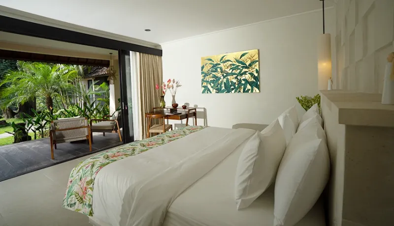 Cozy cottage villa bedroom featuring a large clean bed and sliding glass doors leading to a private patio at Le Sunset Villa