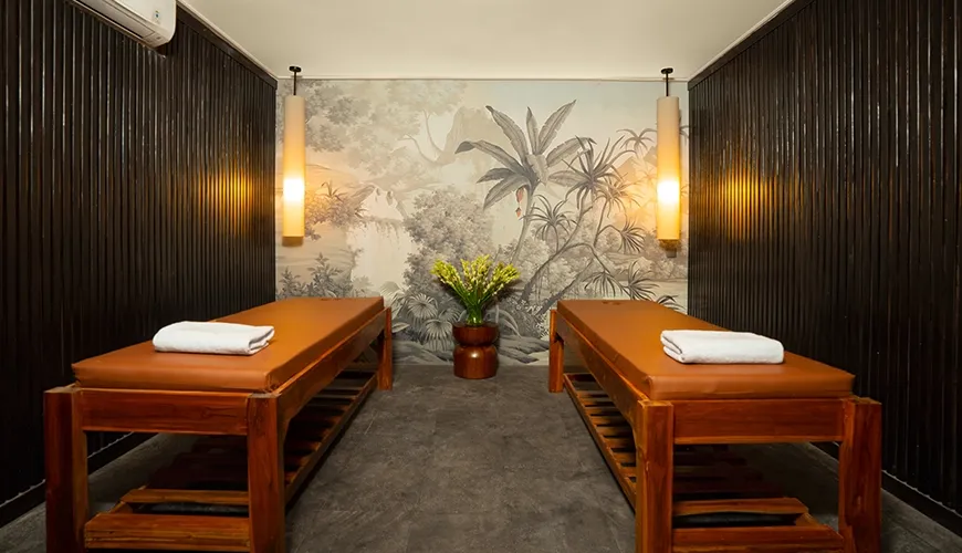 Intimate and relaxing villa spa treatment room with two massage beds and a botanical mural wall at Le Sunset Villa