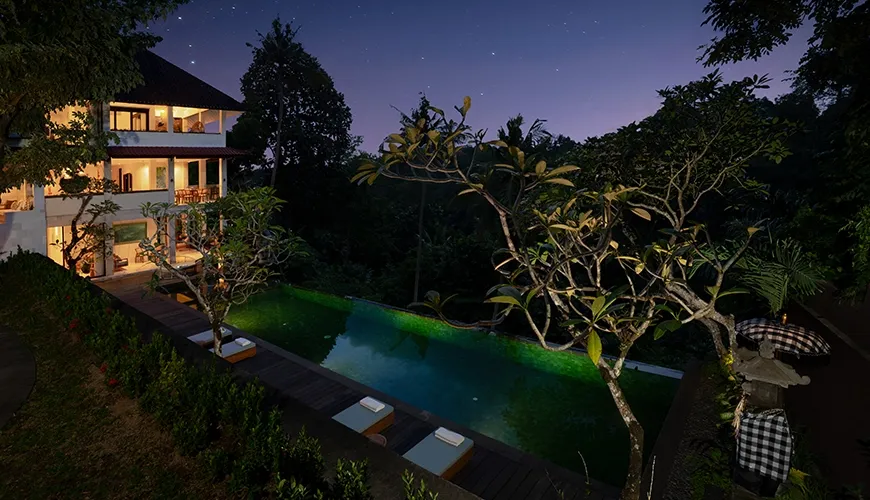 Luxury villa resort infinity swimming pool illuminated at night under a spectacular dark starry sky at Le Sunset Villa