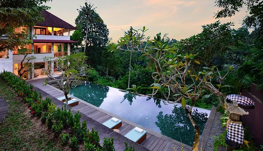 Modern villa pool area with a wooden deck and scenic cliff views during golden hour at Le Sunset