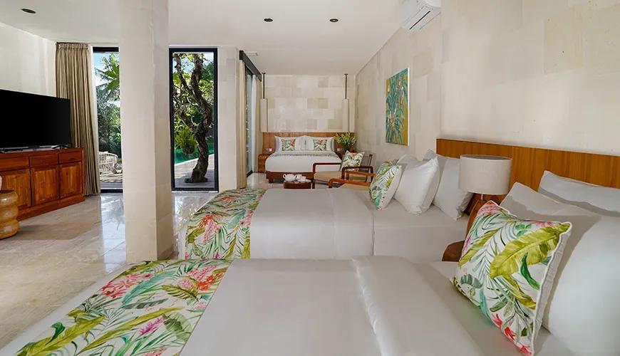 Spacious family room bedroom featuring a large comfortable King bed and a Twin bed with colorful tropical print accents and pillows at Le Sunset
