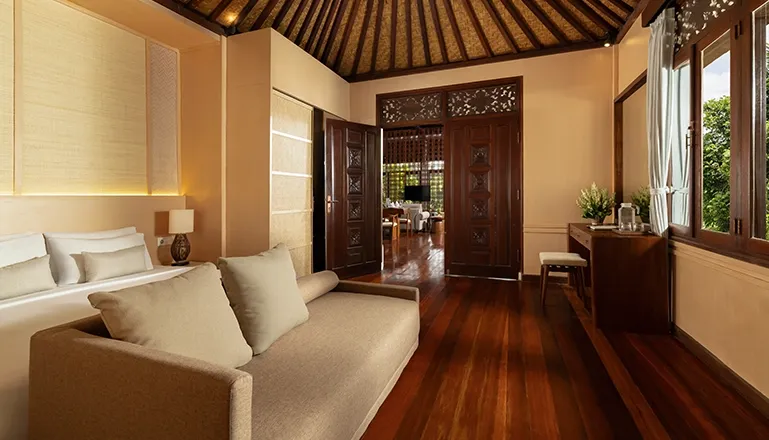 Elegant bedroom with beautiful wooden ceiling and doors overlooking tropical scenery at Leona Suweta