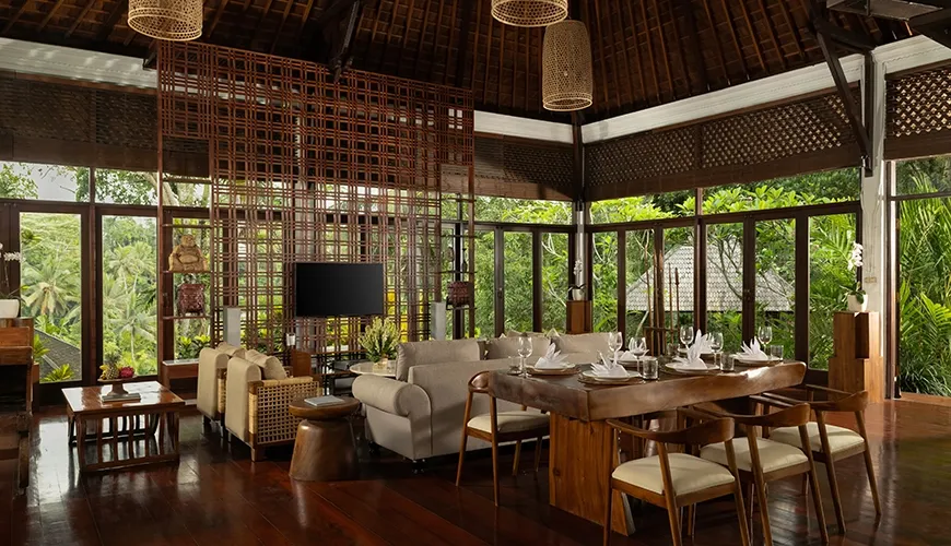 Large open-concept living space features a dining area and lush green views at Leona Suweta