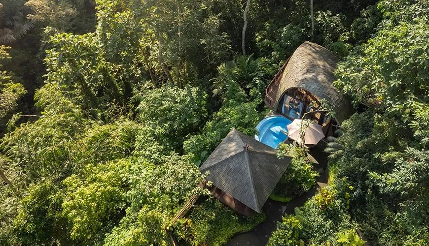 Aerial drone shot captures a secluded villa nestled within vibrant lush greenery at Leona Valley View 1BR